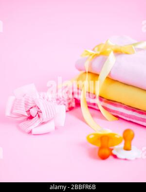 newborn stuff, clothes and pacifier for baby girl on pink background Stock Photo