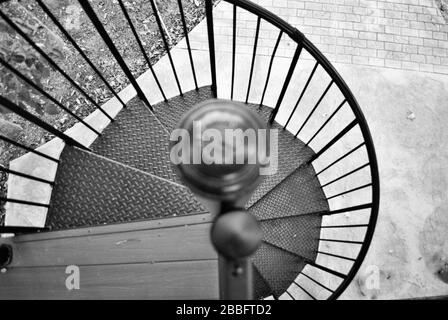 looking down a black and white spiral staircase Stock Photo