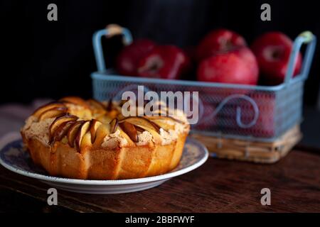 Round apple pie. Homemade pastries. Cupcake with apples on a wooden table. Simple food. Stock Photo