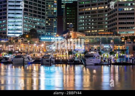 Sydney Darling Harbor in Australia. Modern waterfront entertainment area with Cockle Bay Wharf and yachts at night. Stock Photo