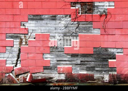 a cracked red shingle tile warehouse wall exposed rotten wood Stock Photo