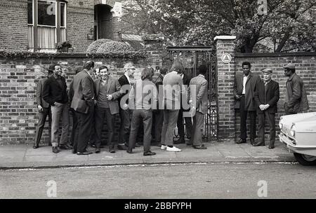 1970s, historical, a group of workers and union members gathered in protest on the pavement outside entrance to a victorian property housing the offices of the British trade union, the Amalgamated Engineering Union (AEU), South London, England, UK. The early 70s were a turbulent time  in industrial relations in Britain with strikes from unions in protest at redundancies and low wages. Stock Photo