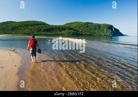 hiker along beach at Old Woman Bay, Lake Superior Provincial Park,  Ontario, Canada Stock Photo