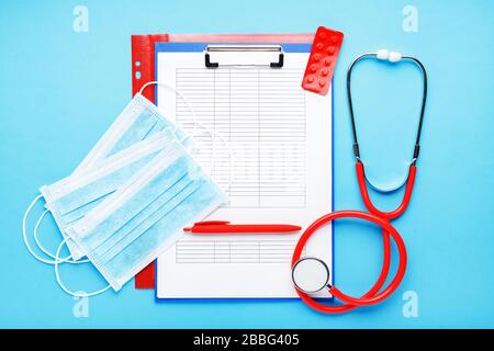 Doctor appointment. Red stethoscope,Medical hygienic masks, tablets, medical documents on doctors workplace in clinic. Concept medicine health care Stock Photo