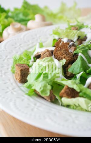 Vegetarian version of classic Caesar salad with mushrooms instead of chicken, croutons, lettuce, parmesan cheese and sauce Stock Photo