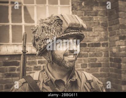 Close up smiling young man isolated outdoors, dressed in American US military man soldier costume, 1940's summer event, Black Country Living Museum UK. Stock Photo