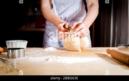 Making dough by female hands on wooden table background Stock Photo