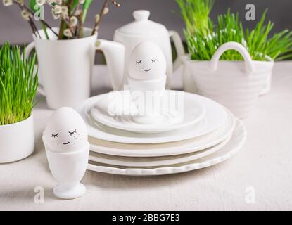 Festive composition Easter eggs with eyes in a white bowl on a table light background. Happy easter concept. Stock Photo