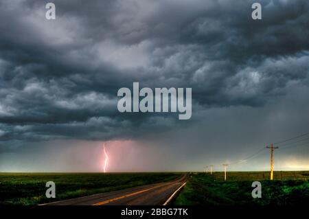 Storm with lightning flashing over highway in rural southern Manitoba Canada Stock Photo