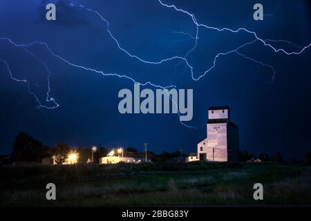 Storm with lightning over old grainery in rural Elkhorn, Manitoba, Canada Stock Photo