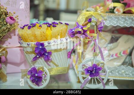 Beautiful flowers decorated in wedding . Bicycle white toy carry purple flowers on the table . Stock Photo