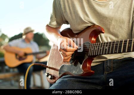 Father and son playing guitar together Stock Photo