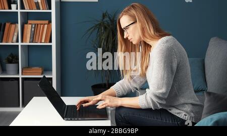 Woman working laptop sitting sofa Stock Photo