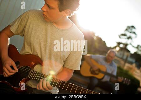 Father and son playing guitar together Stock Photo