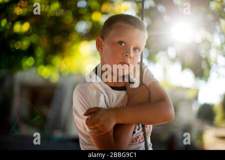 Portrait of a young boy playing on a rope swing Stock Photo