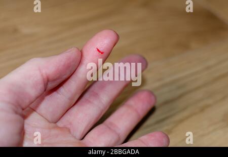 Bleeding from sharp cut wound at left index. Finger cut, bleeding injured with knife. Stock Photo