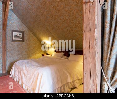 alcove with fabric wallpaper, bed and wooden tramen Stock Photo