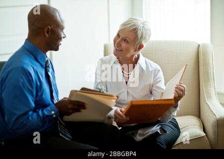 Two mature business colleagues discussing reports Stock Photo