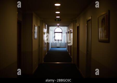 A long dark corridor in the hotel. The electronic clock shows the time. Stock Photo
