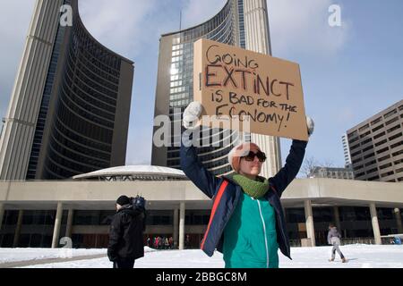 Toronto, Ontario, Canada - 03/01/2019: Young women hold placard to fight for climate change - Global warming and environment - Focus on the placard Stock Photo
