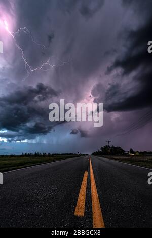 Storm with lightning striking over highway road in rural North Dakota United States Stock Photo
