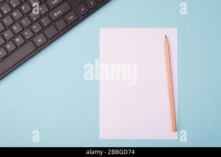 Top above overhead close up view photo of table with blank sheet of paper pen and computer keyboard isolated over background Stock Photo