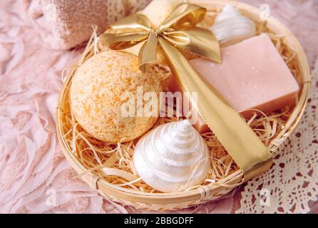 Natural bamboo material gift basket filled with shredded wood excelsior with various spa bathroom products, pink soap bar, bath bomb, natural sponge o Stock Photo