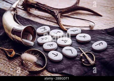 Side view of rune stones with various viking era style objects. Ancient divination and vikings lifestyle concept. Stock Photo
