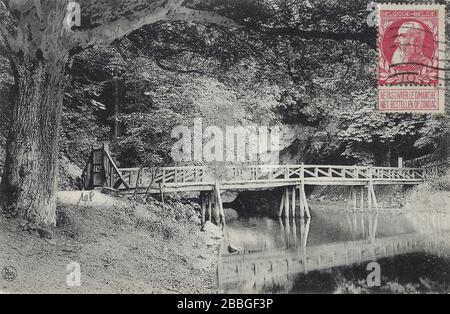 Postcard from around 1910 showing a wooden bridge over the river Lesse, there where it leaves the Caves of Han-sur-Lesse, with a stamp of Leopold II f Stock Photo