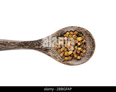 Fermented bee bread also known as fermented bee pollen on wood spoon isolated on white background. Alternative medicine concept. Stock Photo