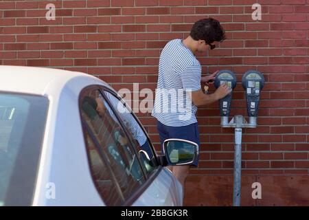 Magog, Quebec, Canada - September 8, 2018: young man, pays for parking. Travel in Canada Stock Photo