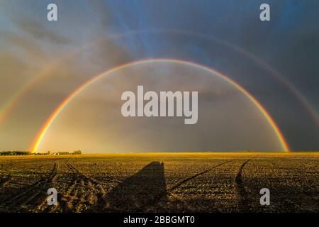 End of storm double rainbow over field in southern Manitoba Canada Stock Photo