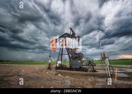 Storm and lightning rolls over oil pump in Southern Manitoba, Canada Stock Photo