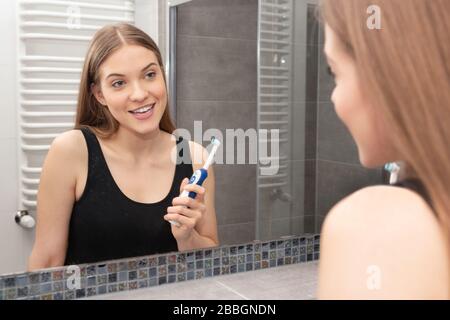 Woman brushing teeth in bathroom. Dental health concept Stock Photo