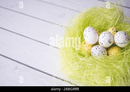 Easter decorations. Eggs in nests on wooden background Stock Photo