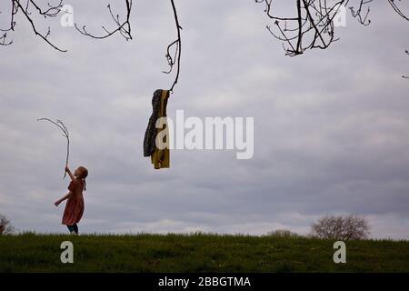 LONDON, UK. A young child observes social- distancing as she plays alone in Mountsfield Park (Lewisham) during the coronavirus pandemic. Stock Photo