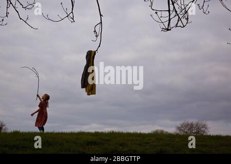 LONDON, UK. A young child observes social- distancing as she plays alone in Mountsfield Park (Lewisham) during the coronavirus pandemic. Stock Photo