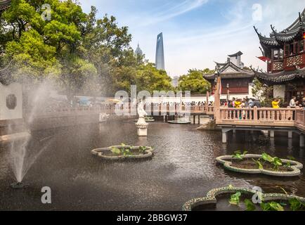 Shanghai, China - May 4, 2010: Yu garden off Yuyuan shopping streets. Landscape, statue of goddess Guanyin in pond with green foliage and SWFC and Jin Stock Photo
