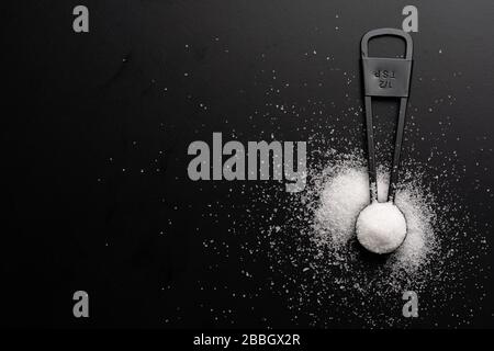 https://l450v.alamy.com/450v/2bbgx2r/a-set-of-black-measuring-spoon-with-salt-on-black-background-2bbgx2r.jpg