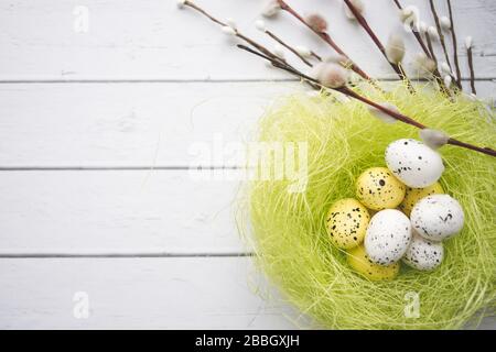 Easter decorations. Willow twigs and decorative Eggs in nests on wooden background Stock Photo