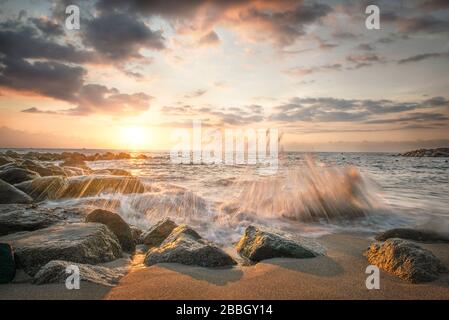 Waves in slow motion crashing onto the beach in Puerto Vallarta Mexico at sunset Stock Photo
