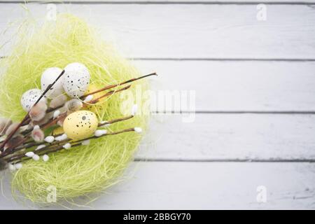 Easter decorations. Willow twigs and decorative Eggs in nests on wooden background Stock Photo