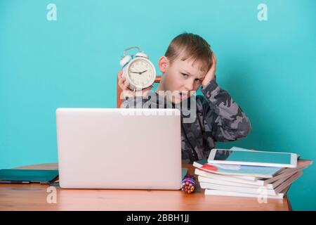 School kid using laptop while doing schoolwork at home. Homeschooling. School from home. Stock Photo