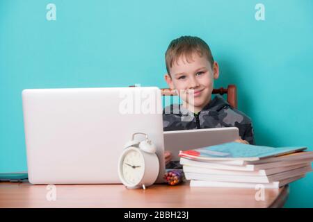 School kid using laptop while doing schoolwork at home. Homeschooling. School from home. Stock Photo