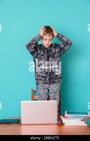 School kid using laptop while doing schoolwork at home. Homeschooling. School from home. Stock Photo