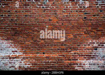 A full frame background of a rough and textured brick wall with visible wear and tare and copy space Stock Photo