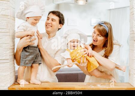 Caucasian parents are holding the twins in white cap Stock Photo