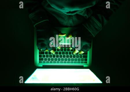 top view of hooded hacker stealing data from laptop  Stock Photo