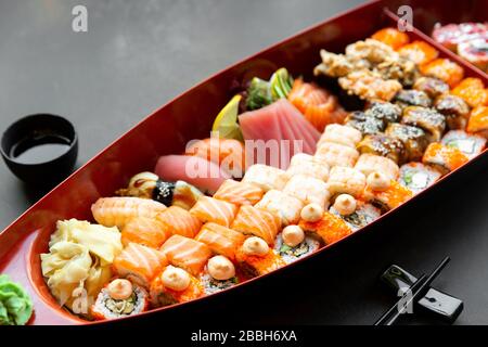japanese sushi food. Various kinds of sushi served on a boat close up. Big set of rolls on a plate in a restaurant. Stock Photo