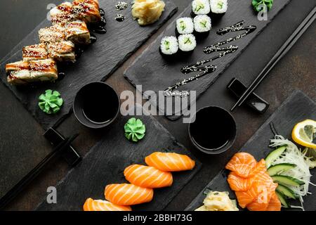 japanese sushi food. Various kinds of sushi served on a plates close up. Big set of rolls on a plate in a restaurant.  Stock Photo